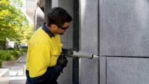 Close-up of contractor applying sealant to joint