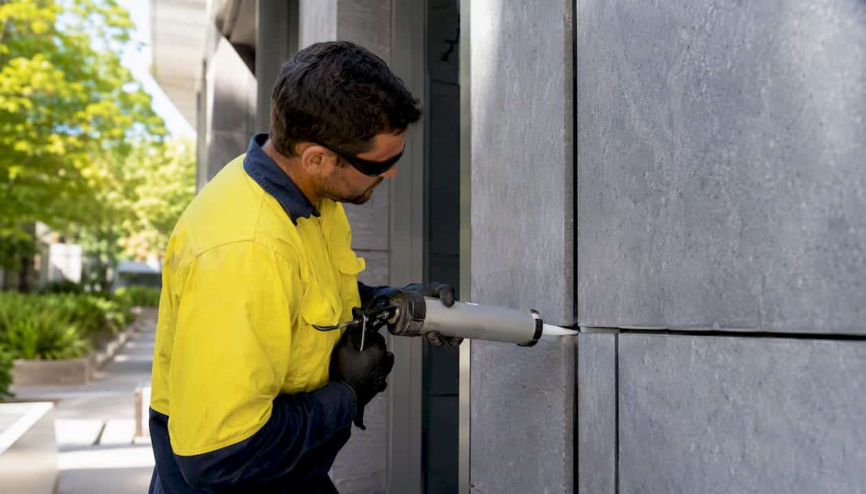 Close-up of contractor applying sealant to joint