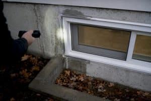 Basement window with moisture stains and cracks