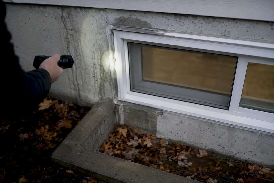Basement window with moisture stains and cracks