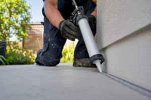 Close-up of technician applying sealant on building joint