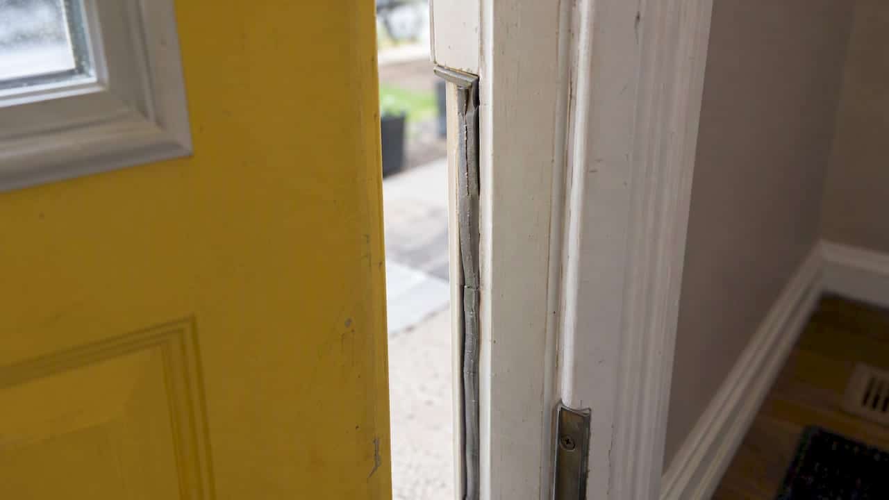 Cracked weatherstripping along an exterior door jamb