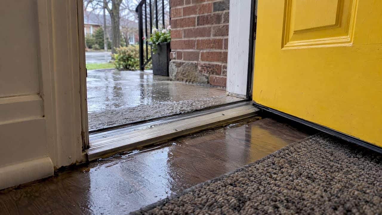 Rainwater entering beneath a yellow exterior door
