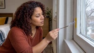 Homeowner checks window draft with incense