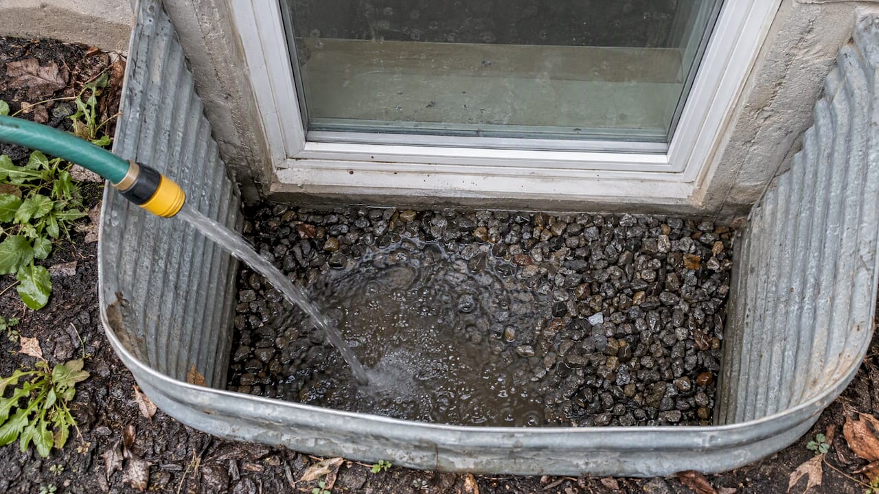 Hose test checks drainage in gravel window well